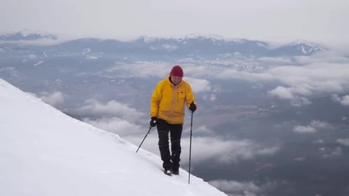 Hiker Trekking Up Snowy Mountain in Winter