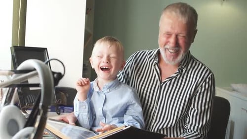 Grandfather and Boy Enjoying Photo Album Together