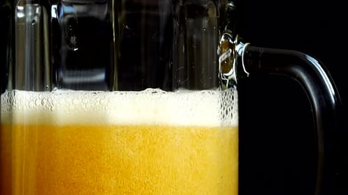 Beer Pouring into Glass Mug in Close Up