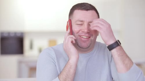 Man Smiling and Talking on a Cell Phone
