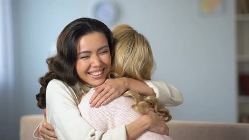 Smiling Women Sharing a Warm Embrace Indoors