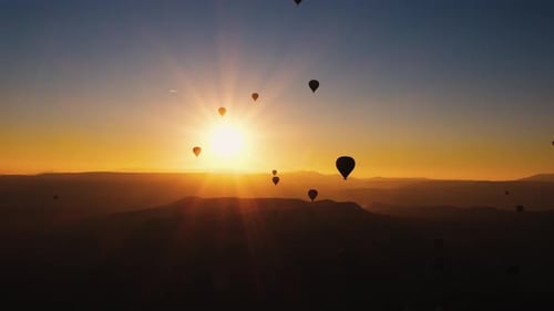 Sunrise Balloons over Mountain Landscape