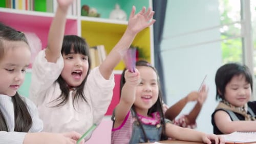 Multi-ethnic young boys and girls happy funny study and play painting on paper at elementary school.