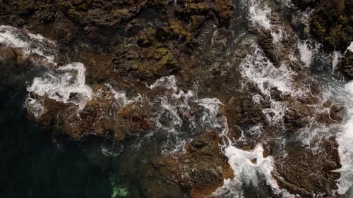 Olas del océano chocando sobre rocas volcánicas