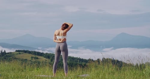 Woman Stretching in Mountain Meadow for Health and Fitness
