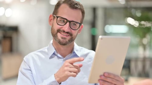 Man Video Calling on Tablet in Workplace
