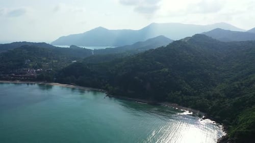Wide angle overhead tourism shot of a sandy white paradise beach and aqua turquoise water background
