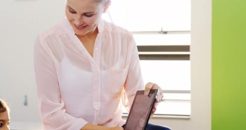 Teacher Instructing Student with Tablet in Classroom