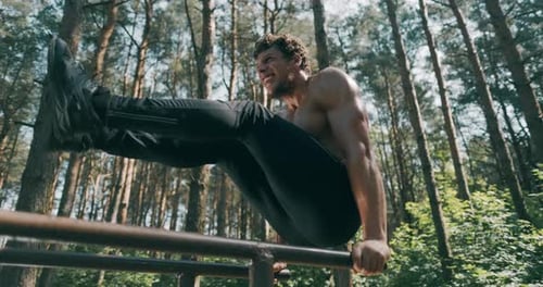 Man Working Out on Parallel Bars in Forest