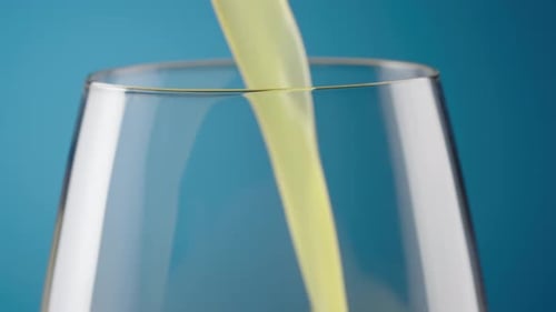 Yellow Drink Poured into Glass Close Up