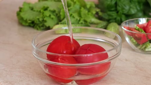 Tomatoes in Bowl Being Washed for a Salad