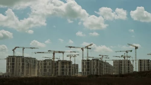 Timelapse of a large construction site with many cranes working over buildings