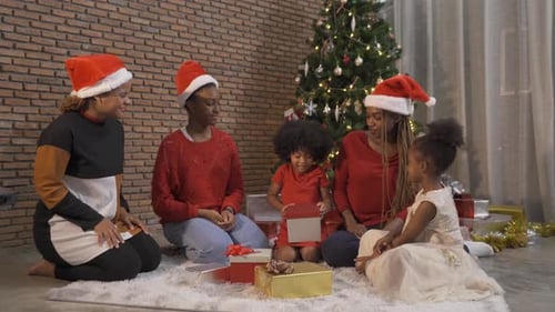 African American black family, women and kid girl daughters sharing gifts on Merry Christmas