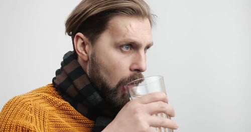Man Taking Pill With Glass of Water