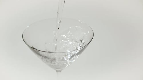 Clear Liquid Being Poured into Martini Glass