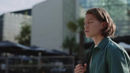 Male Hipster in Casual Wear Walking on Street with Backpack