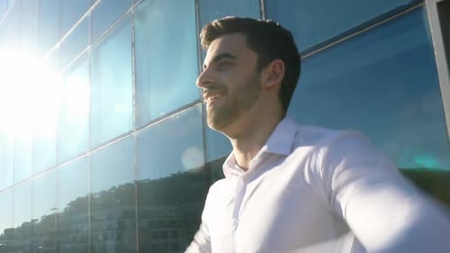 Man Celebrates Success Outside Modern Office Building