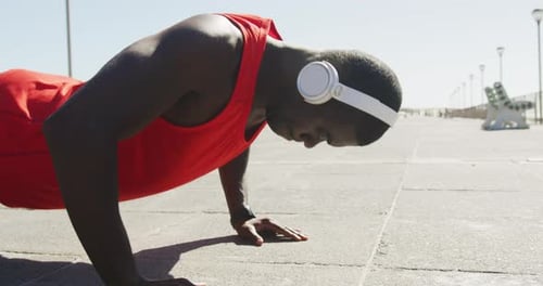 Man Doing Pushups on Boardwalk by Beach