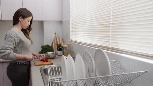Woman Prepares Tomatoes in Sunny Kitchen