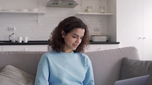 Woman Using Laptop Computer at Home on Couch