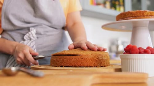 Woman Slicing Delicious Yellow Cake at Home