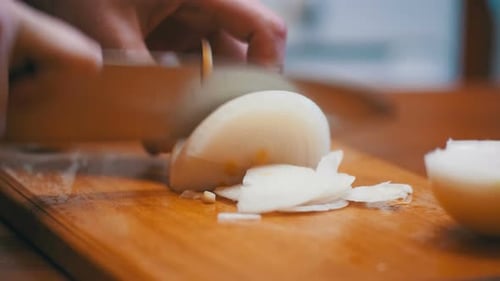 Chef Slicing White Onion on Cutting Board
