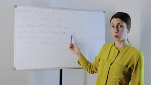 Woman Teaching Math at Whiteboard in Classroom