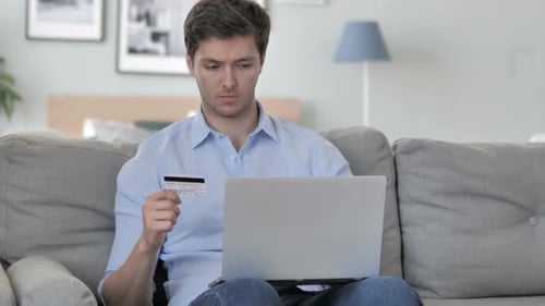 Man Shopping Online Using Laptop and Credit Card