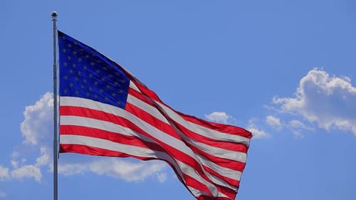 American Flag Waving Proudly Against Blue Sky