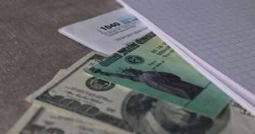 Stimulus Economic Tax Return Check and USA Currency Hundred US Dollar Bills 1040 U