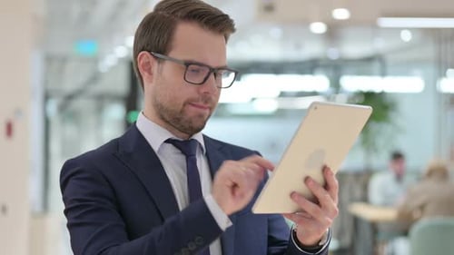 Businessman Uses Tablet and Reacts with Success