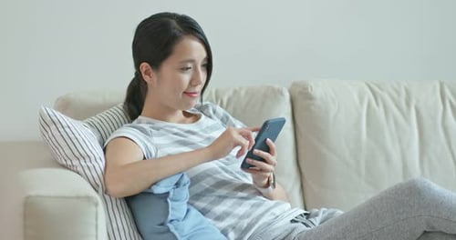 Woman Using Smartphone on Couch