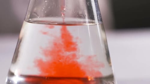 Red Dye Added to Liquid in Scientific Flask