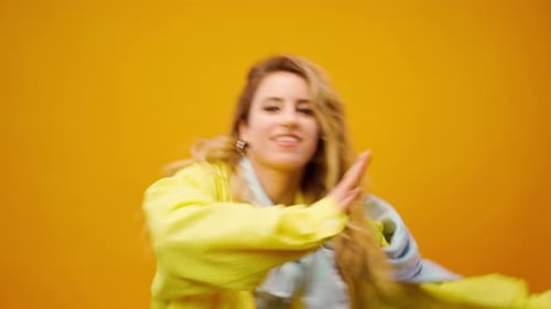 Woman Professional Dancer Dancing in Studio Against Yellow Background
