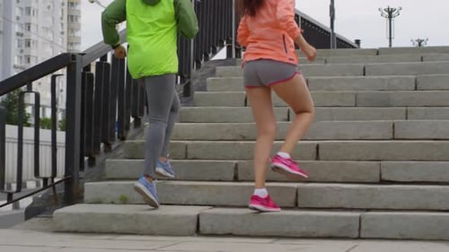 Women Jogging Up Stone Steps in City