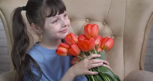 Little Girl with Tulips Bouquet Smelling Flowers