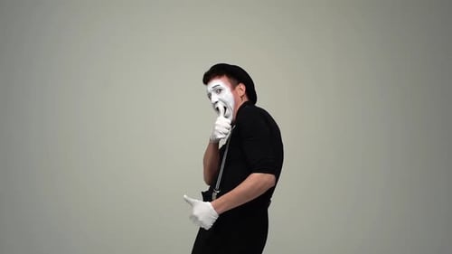 Porträt eines glücklichen männlichen Pantomime zeigt Okay und Daumen hoch Handgesten und zwinkernde Empfehlung