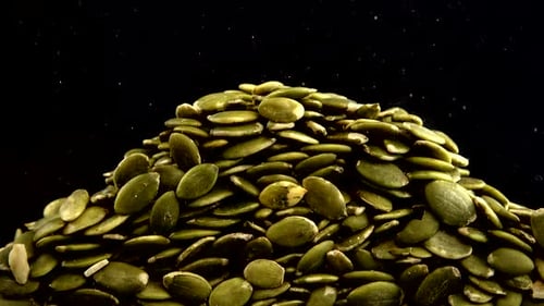 Green Pumpkin Seeds Falling onto Pile, Macro Shot