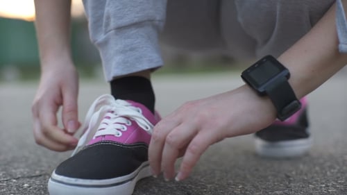 Woman Tying Shoelaces with Smartwatch