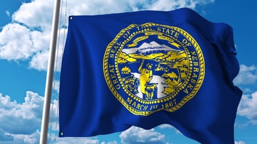 Nebraska State Flag Waving with Blue Sky and Clouds