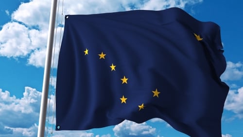 Realistic Alaska State Flag Waving in Wind against Blue Sky