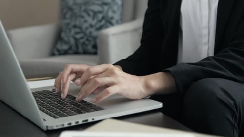 Young Woman Working at the Modern Office Desk with a Laptop