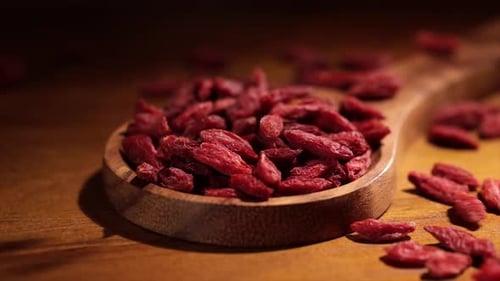 Goji Berries Poured into a Wooden Spoon
