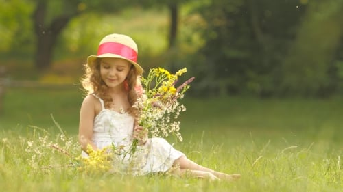 Girl with Flowers Sitting in Sunny Meadow