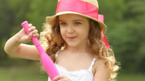 Little Girl Blowing Bubbles in a Summer Park