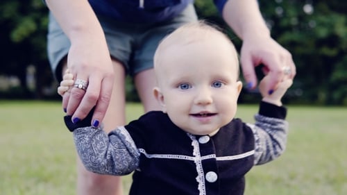 Happy Baby Learning to Walk on Green Lawn