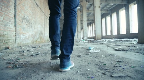 Person Walking in Abandoned Derelict Building