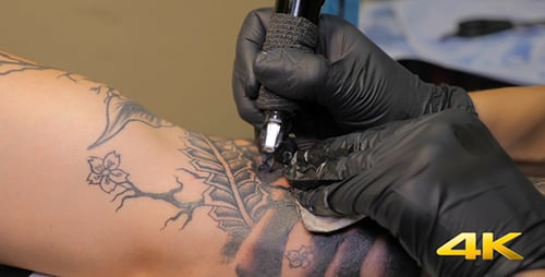 Tattoo Artist Inking Arm with Tattoo Machine