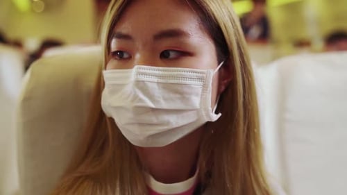 Traveler Wearing Face Mask While Traveling on Commercial Airplane