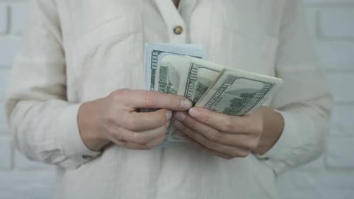 Adult Counting US Hundred Dollar Bills